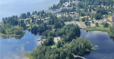 Ilmakuva Keuruun kaupungista, jossa rakennuksia ympäröivät metsät ja järvimaisema.