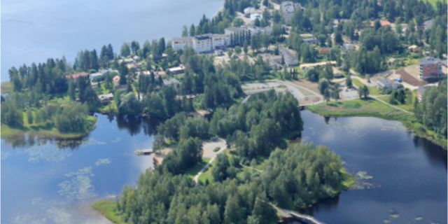 Ilmakuva Keuruun kaupungista, jossa rakennuksia ympäröivät metsät ja järvimaisema.