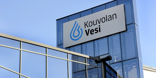 Kouvolan Veden toimistorakennus, jonka katolla näkyy yhtiön logo ja nimi kirkasta sinistä taivasta vasten.